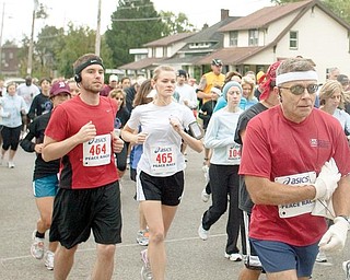 OFF AND RUNNING: Joe Scalzo, a Vindicator sports writer, left, runs his third Peace Race. Scalzo crosses the starting line Sunday on West Indianola Avenue with his wife, Tiffani, center, running her first 10-kilometer race. 