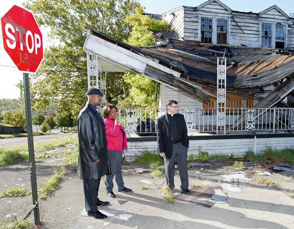 TAKE IT DOWN: ACTION, a faith-based, grass-roots community organization, wants Youngstown to demolish the long-vacant Linton Funeral Home on the North Side. Among those calling for the building to come down are, from left, Byron Armour, a North Side resident; Rose Carter, an ACTION organizer, and Pastor Joseph Rudjak of Sts. Peter and Paul Church.