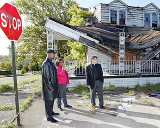 TAKE IT DOWN: ACTION, a faith-based, grass-roots community organization, wants Youngstown to demolish the long-vacant Linton Funeral Home on the North Side. Among those calling for the building to come down are, from left, Byron Armour, a North Side resident; Rose Carter, an ACTION organizer, and Pastor Joseph Rudjak of Sts. Peter and Paul Church.