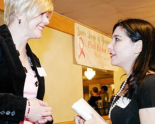 SURVIVORS IN PINK: Geralyn Lucas, right, writer of the book and screenplay, “Why I Wore Lipstick to My Mastectomy,” talks with Patti McSuley of Boardman on Monday at the Pink Ribbon Tea at The Georgetown in Boardman. McSuley, who works at Regis Salon in Southern Park Mall, is a breast-cancer survivor and by coincidence, styled Lucas’ hair.