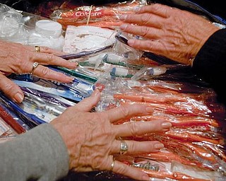 HELPING HANDS:  Volunteers sift through dental supplies donated from area churches and businesses. The supplies will be transported to San Jose Villanueva, El Salvador, as part of a mission trip that includes members of Ursuline High School’s class of 1958.