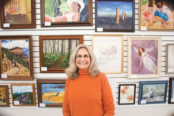ART ON DISPLAY: Suzanne Bort Gray is the art coordinator at the Davis Family YMCA in Boardman. The pieces on display behind her were created by members of the Y and students in Gray’s Y classes. 