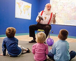 STORY TIME: Bill Dick, of Goshen Township, reads from his new book, “Santa Meets God’s Ukrainian Children,” to Zachary Smith, 4, of Columbiana, and Anna and Luke Shevchik, 2 and 5 respectively of Greensburgh, Pa. They were at the Children’s Center for Science &amp; wTechnology, 139 E. Boardman St., on Friday.