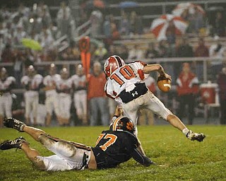 Columbiana's QB (10)Austin Barbato looks to get away from Springfield's (77) Thomas Bobosky during their game on Friday night. Photo/Mark Stahl