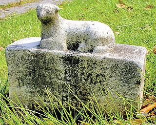 Set just inches tall, the stone marker of a young child is worn away by time
