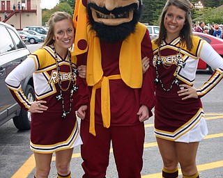 "South Range cheerleaders Dominique Bishop and Jesse Heck hang out
with the Raider mascot at the Blitz tailgate party."