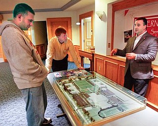 SUPER MODEL: Austintown Superintendent Vince Colaluca, right, explains to Rich Klena, left, the model of the proposed campus-style layout for the school district if a 2.9-mill bond issue passes next month. In the center is the Rev. Rick Stauffer, pastor of Tabernacle Evangelical Presbyterian Church, where a town-hall meeting took place. If passed, the bond issue would fund the 53 percent local share of a $50 million expansion project.