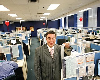 NEW HOME: Chris Butcher, senior operations manager at VXI Global Solutions, stands among new operators at the company’s downtown call center. Butcher, a Mahoning Valley native, was working in Los Angeles when he suggested VXI consider Youngstown for a call center. 