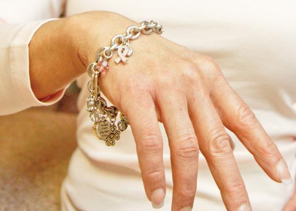 SYMBOL OF LIFE: Castranova models a charm bracelet with a breast-cancer symbol. October is Breast Cancer Awareness Month, and Castranova said her self-exam might have saved her life.