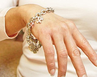 SYMBOL OF LIFE: Castranova models a charm bracelet with a breast-cancer symbol. October is Breast Cancer Awareness Month, and Castranova said her self-exam might have saved her life.