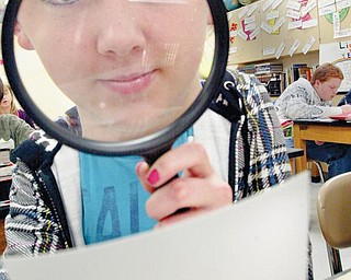 LOOKING CLOSER: Alexis Cloud, an eighth-grader at Girard Junior High School, gets a closer look at fingerprints during a class project to find out who may have stolen some money from a teacher by using crime-solving techniques seen on popular TV shows such as “CSI.”
