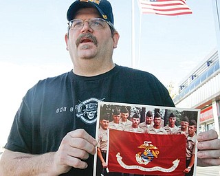 SOMBER REMINDER: Anthony Kolat of New Middletown holds up a picture of fellow Marines with whom he served. He was on one side of a compound in Beirut, Lebanon, on Oct. 23, 1983, when a suicidal truck bomber killed 241 U.S. service members, 220 of whom were Marines.
