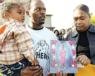 family: Crystal and Michael Howell hold a photo of their daughter, Jabraya, an East High School cheerleader who died Wednesday. Michael is holding Jabraya’s brother, Michael Jr., 2, as they marked Jabraya’s 17th
birthday Thursday.
