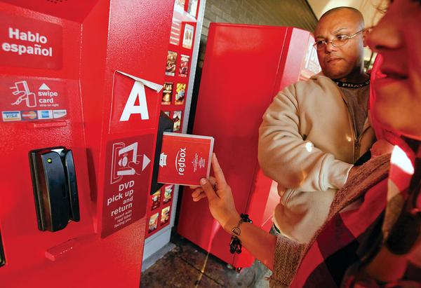 Enrique Cruz, left, and his wife Darlene Cruz return some DVD's at the Red Box movie rental vending machines outside Tony's Finer Foods on 4600 W. Belmont, October 6, 2009, in Chicago, Illinois.