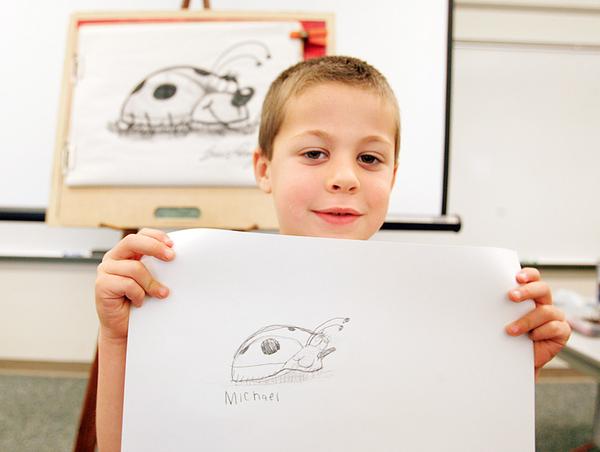 Michael Nittoli, a kindergarten student, shows off his lady bug drawing at Dobbins Elementary School in Poland. The students received an art lesson from Bruce Langton, a children’s book illustrator, to promote literacy.