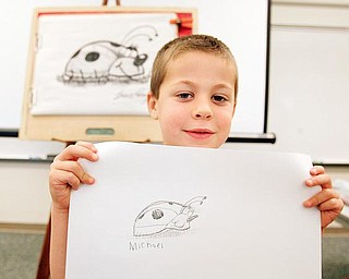 Michael Nittoli, a kindergarten student, shows off his lady bug drawing at Dobbins Elementary School in Poland. The students received an art lesson from Bruce Langton, a children’s book illustrator, to promote literacy.