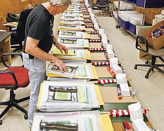 READY TO GO: Joe Rakocy, foreground, and John Ferraro, employees at the Mahoning County Board of Elections, get supplies ready for polling locations at the county’s South Side Annex on Market Street in Youngstown. Today is Election Day in Ohio and Pennsylvania.