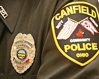 SERVE AND PROTECT: Paul Lasky, juvenile officer with the Canfield Police Department, displays this badge at Canfield High School. Lasky has more than 30 years of experience in law enforcement and has been involved with Canfield schools since 2000.