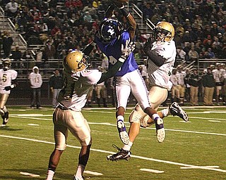 POLAND - (4) Darius Patton has the ball go off his finger tips as (21) Doran Grant and (37) Mark Murphy defend on the play during their game Friday night in Poland. - Special to The Vindicator/Nick Mays