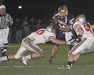 MCDONALD - (31) Zach Tura picks up yardage against (10) Miles Chapman and (36) Jaren Wickham of the Chieftains defense Saturday night. - Special to The Vindicator/Nick Mays