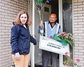 LUCKY WINNER: The Publishers Clearing House’s Kaitlyn McCoy, of Long Island, presents a check for $10,000 to Herman Starks at his home in Liberty on Tuesday afternoon.