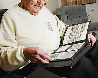 REMEMBERING: Paul Sovik of Youngstown looks through some old pictures that bring back memories of the battles he fought in during World War II in the Pacific. He enlisted in the Marine Corps on Dec. 8, 1941, the day after the Japanese attack on Pearl Harbor.
