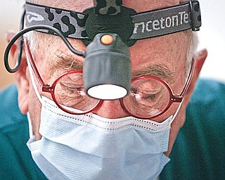 MOBILE DENTIST: Dr. Bell wore his head lamp as he worked on the elementary students.