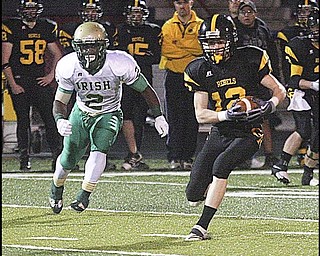 FOOTBALL - (12) Tristan Reynolds looks for running room after a completed pass as (2) Nico Irizarry gives chase during their game Friday night in Austintown. - Special to The Vindicator/Nick Mays