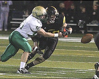 FOOTBALL - (58) Pete Wearsch of Ursuline knocks the ball from Andrew Mayer during their game Friday night in Austintown. - Special to The Vindicator/Nick Mays