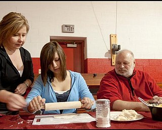 The Vindicator/Geoffrey Hauschild
Donna Zubil helps her daughter, Codi Zubil, 17, both of East Palestine, emerse themselves in their Polish heritage by rolling out dough for the making of pirohy or pierogies while overseen by workshop leader, Larry Kozlowski, of Erie, during The Artistry of Wigilia (Christmas Eve) benefitting the Krakowiaki Polish Folk Circle at St. Joseph the Provider Church in Campbell on Saturday afternoon. "These traditions act as a catalyst to bring your family together," says Kozlowski, "its about teaching traditions that have been lost or never known in addition to remembering memories and making new ones."