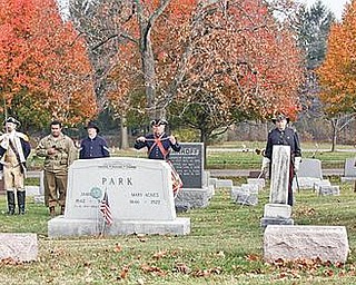 SALUTE: War re-enactors honor the fallen of three wars at a ceremony Sunday at Canfield Cemetery.