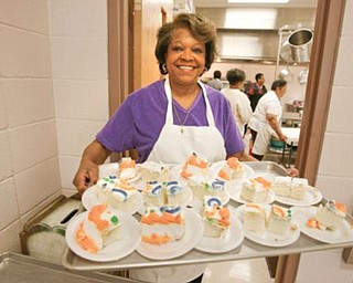 SWEET TREAT: Rosalind Willis, coordinator of the Wednesday free lunch at St. Andrewes AME Church, holds a tray of pieces of cake. The church recently revived its tradition of offering a free meal. Those attending are served restaurant style. This week, about 153 people attended.