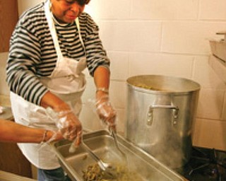 COOK IN THE KITCHEN: Ethel White, a member of St. Andrewes African Methodist Episcopal Church, 531 W. Earle Ave., Youngstown, transfers steaming green beans to a serving dish from a large kettle. She’s among church members who volunteer at the free lunch for all on Wednesdays.