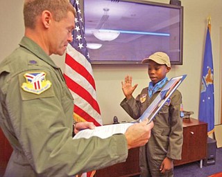 TAKING THE OATH: Alan Hinton, of Youngstown’s North Side, who was chosen for the “Pilot for a Day” program at the Youngstown Air Reserve Station, is sworn in Wednesday by Lt. Col. Craig Peters, the operations group commander.