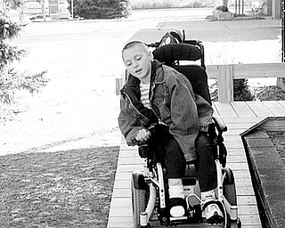 Special to The Vindicator
PRIVATE DRIVEWAY: Although his movements are limited by cerebral palsy, Tyler Wibly, a student at the Frank Ohl Intermediate School, skillfully drives his new power chair up a specially designed ramp. When it was discovered the old ramp could not handle the weight or center-wheel drive of his new chair, his parents turned to the Rotary Club of Austintown for help, and the club contacted the Optimist Club of Austintown for assistance. Materials for the ramp were purchased with funds provided by Rotary, and volunteers from both clubs were helped by Tyler’s parents as they worked together to construct the ramp.