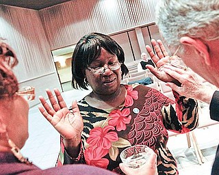 HANDS BLESSED:  Rose Wilkins of Youngstown, center, was one of a dozen people who turned out Monday for the first Blessing of the Hands service,  presented by SouthernCare, a hospice organization.  She had her hands blessed by Dr. Nicholas Mager, right, pastor of the Youngstown First Presbyterian Church, as Sylvia Beard, SouthernCare chaplain, assisted. 