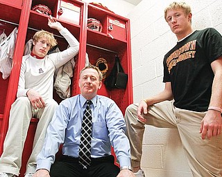 FAMILY AFFAIR: Cardinal Mooney Assistant football coach Ron Stoops, center, is flanked by sons John, left, and Joe in the Mooney football locker room.

