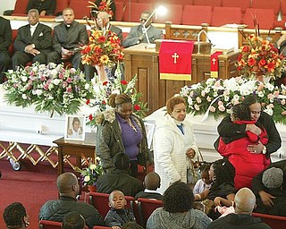 Mourners embrace family members of Wilneice Green, and her daughter, Ja’Brayasia (also written as Ja-Brajasia), during a funeral service Monday at Elizabeth Missionary Baptist Church in Youngstown. About 300 attended the service. The Greens were murdered Nov. 15 in their home in Liberty Township.