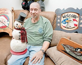 WOOD WORKER: Tom Capp of Cornersburg displays woodworking and painting projects at his apartment. Capp’s work will be on display at Piccadilly’s Fine Art Galleries in Cleveland’s Tremont neighborhood today through next Friday.
