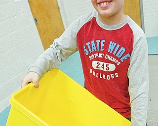 RECYCLE CHALLENGE: Poland North Elementary School fourth-grader Tyler Campbell holds a recycling bin during a program about recycling at his school. The school is participating in a contest to win a trip to Disneyland.
