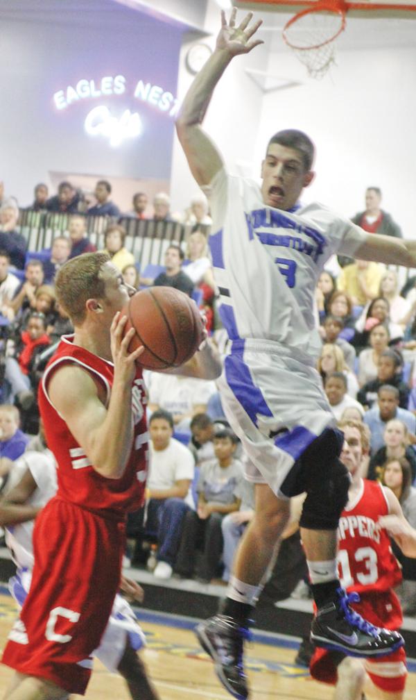 CLIPPERS CLIPPED: Youngstown Christian’s Caleb Yanno (3) blocks a shot by Columbiana’s Zach Chaplow (32) during Tuesday’s game at Youngstown Christian High School. The Eagles defeated the Clippers, 93-71. 