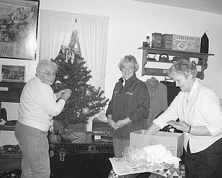 Special to the Vindicator
TREE-TRIMMING: Hubbard Historical Society members, left to right, Joan Gibson, Cecilia Cooper and Lucille Wilson decorate one of the six Christmas trees at the McBride House, 27 Hager St. The house, decorated for Christmas, will be open from 2-5 p.m. Sunday. Gift items for sale include note cards, a historic afghan throw depicting early scenes of Hubbard, the book “Hubbard” by Barbara Emch, a selection of Cat’s Meows, and Christmas tree bulbs featuring the Stewart-Kyle Funeral Home and the Tylee Park Gazebo. For information about the open house or any of the gift items, phone Cecilia Cooper at (330) 534-4247.