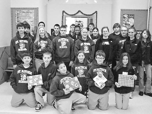 Special to The Vindicator
GIFT GIVERS: The Builders Club of St. Patrick School in Hubbard was dedicated this season to bringing holiday cheer to students at the Rich Center for Autism, on the campus of Youngstown State University. Club members, above, hold some of the gifts they purchased with their own money while shopping after school hours. The 20 gifts were wrapped and delivered to the center. Made up of seventh- and eighth-grade students at the school, the club is committed to helping fellow students and community members through service projects.