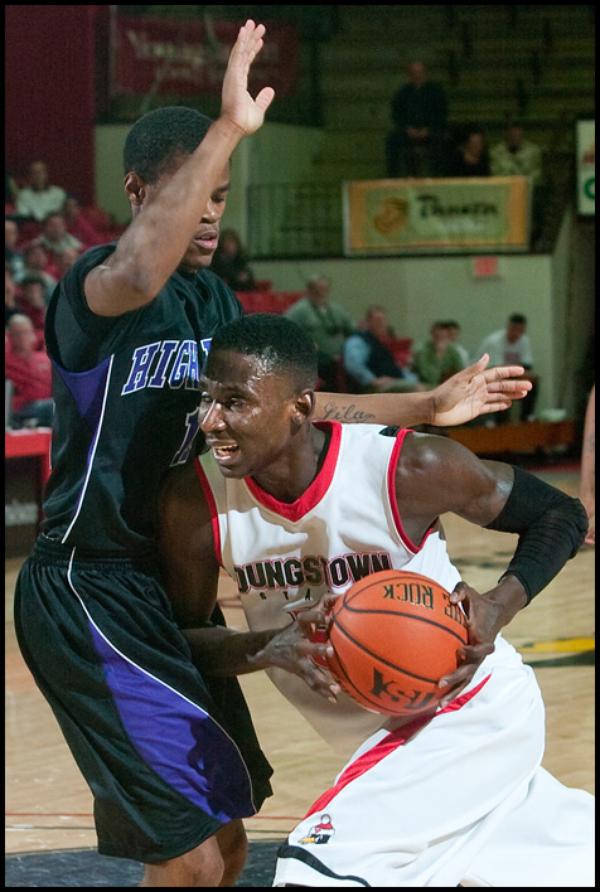 The Vindicator/Geoffrey Hauschild
YSU's Sirlester Martive (5) makes his way to the hoop while being defended by High Point University's David Singleton (11) during the second half of a game at Beeghley Center on Tuesday evening.