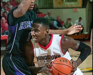 The Vindicator/Geoffrey Hauschild
YSU's Sirlester Martive (5) makes his way to the hoop while being defended by High Point University's David Singleton (11) during the second half of a game at Beeghley Center on Tuesday evening.