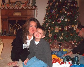 Posing in front of the tree at Beth Hatalsky's home in Mineral Ridge on Christmas morning are her daughter, Tina Miller, and her 6-year-old grandson, Jaxon. Behind them is Beth's son-in-law, Jeff Miller. The Millers are of Poland.