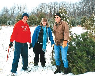 Billy Speece , Karissa and Tom drag a tree from Speece Tree Farm.