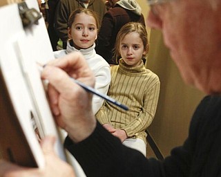 The Vindicator/Lisa-Ann Ishihara --- Sisters Abbey (9) and Alexandra (7) Porter of Girard get drawn by Cartoon & Caricature artist Ed O'Malley of Boardman on the suite level at the Covelli Centre for First Night Youngstown 2010
