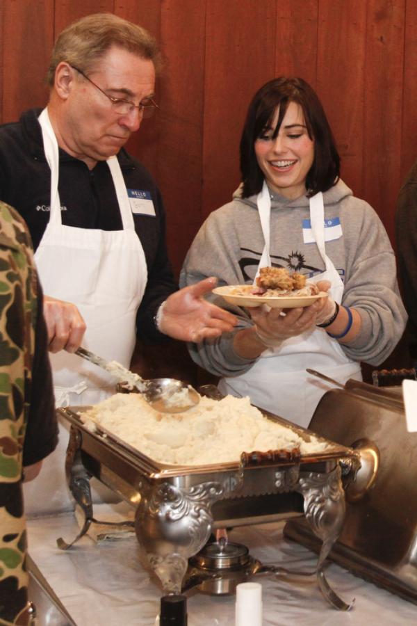 The Vindicator/Lisa-Ann Ishihara -- Gary Robinson of Warren and Sara Stassinis of Cortland fills the plates attendants at Aulizio's Banquet Center in Warren for the free christmas dinner. Sara said she "wants everyone to know that this holiday we should remember in our hearts that Jesus is our lord and savior and its a blessing to help all of these beautiful people. "