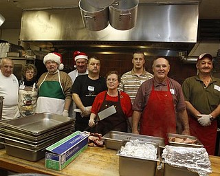 The Vindicator/Lisa-Ann Ishihara -- L-R Pete Orfanos of Warren, Jean and her husband Gary Engstrom of Warren, John Messersmith of Hartford, Steve Matthews of Mineral Ridge, Nancy Jenkins of Warren, Adam Hineman (originally from Cortland, now lives near Cleveland) Carl Antonelli of Champion and Rick Bowser of Andover volunteer their time in the kitchen at Aulizio's Banquet Center in Warren for the free christmas dinner